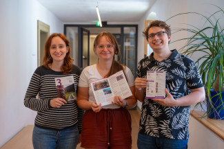 Drei Menschen halten den Gemeindebrief in die Kamera.